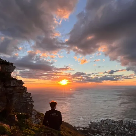 A walker on Lion's Head at sunset above the sea